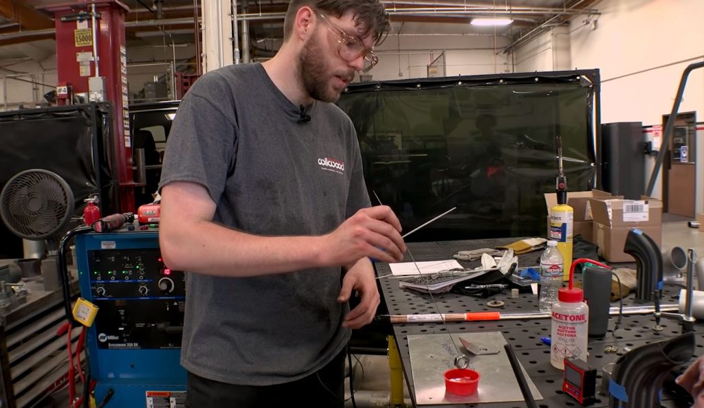 Before installing the steering linkage bracket, Erik does a quick science demo.